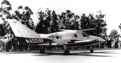 The P.O.C. aircraft watched by an interested crowd in an idyllic setting